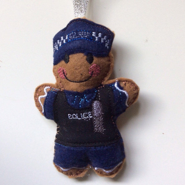 Police officer gingerbread decoration in navy blue uniform and tactical vest.