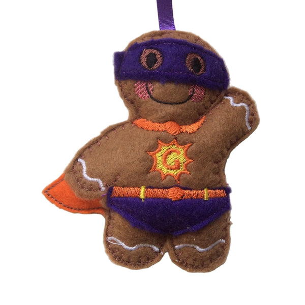 Felt gingerbread man ornament with superhero cape and mask on a white background