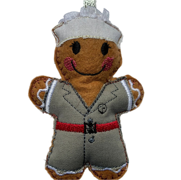 A gingerbread  decoration in a traditional military nurses uniform featuring a brown body with a grey and red uniform, and a smiling face.