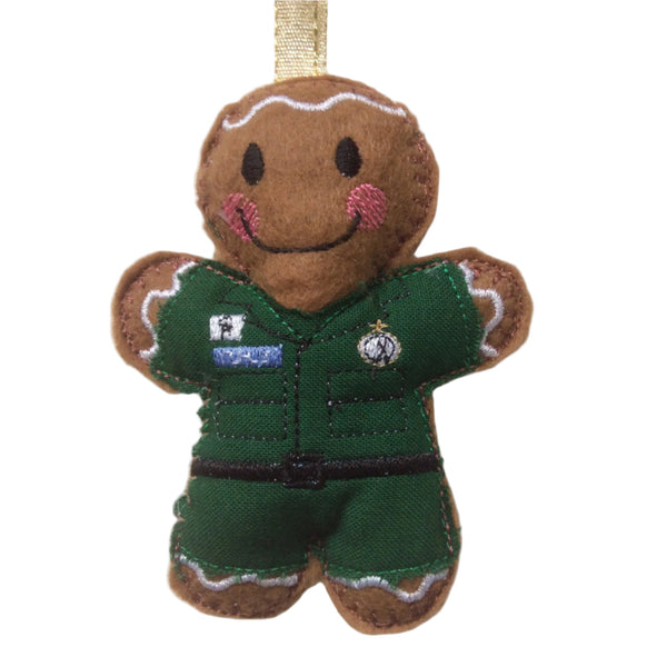 Felt gingerbread man decoration dressed in a  green paramedics uniform on a white background