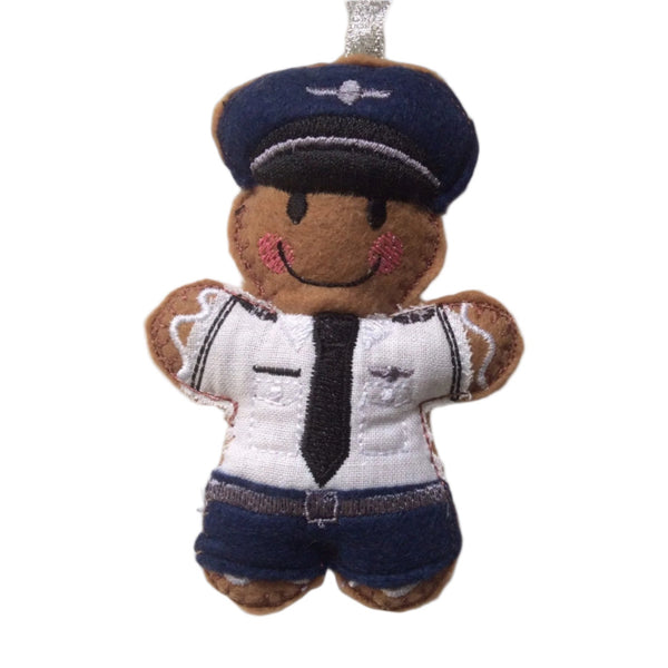 Gingerbread man decoration dressed in a pilot's outfit. In navy, white and silver uniform, designed to be a novelty or decorative item.