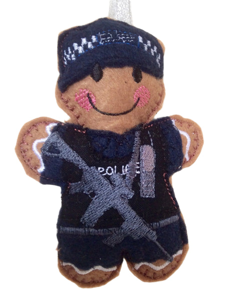 A gingerbread man decoration in a navy blue armed police uniform, with embroidered details and a smiling face. Displayed on white background.