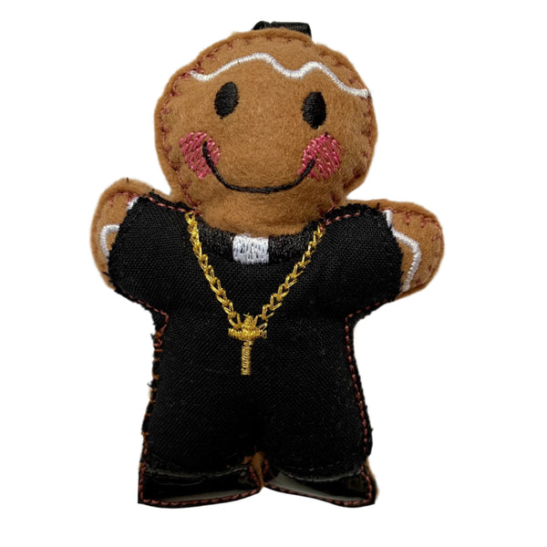 Priest gingerbread decoration with metallic gold cross neck chain on white background.