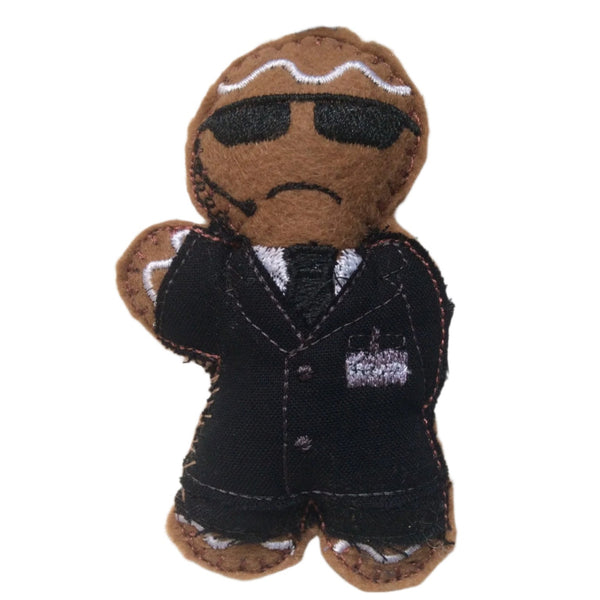 Secret agent gingerbread man decoration in black suit with  sunglasses and earpiece on white background.