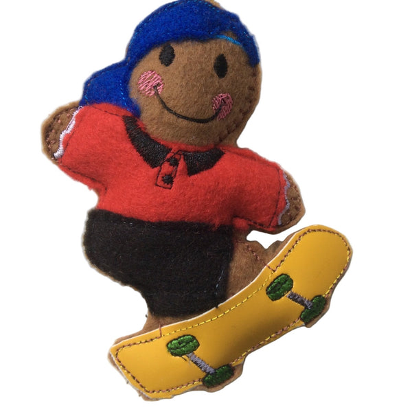 Gingerbread man decoration with a red shirt blue cap and black trousers, riding a yellow skateboard, made from quality felt with a polyester filling.