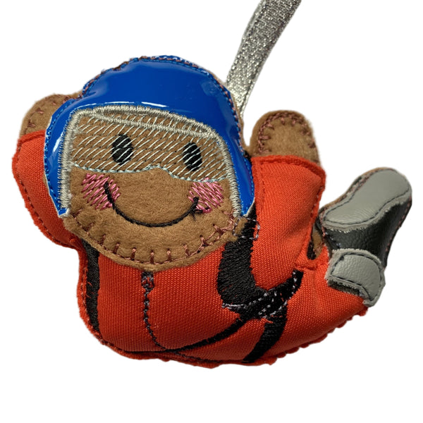 Skydiving felt gingerbread decoration wearing red suit and blue helmet. On white background.