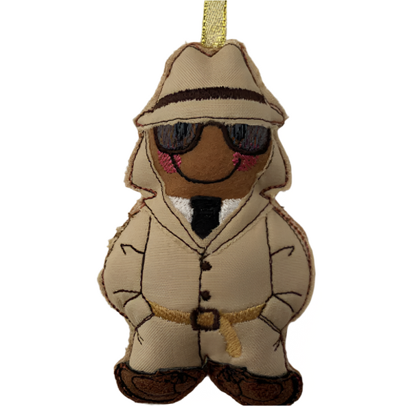 A gingerbread man decoration designed as a spy with a hat, glasses, and a suit.